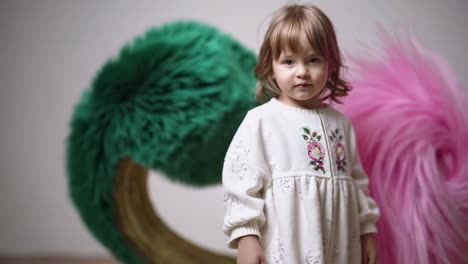 young child interacting with colorful fluffy abstract shapes