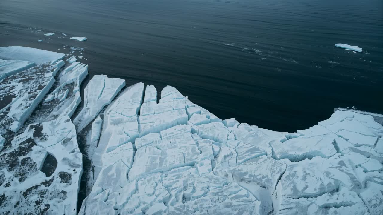 Ripresa panoramica con camera che mostra una piattaforma di ghiaccio marino fratturata, mare polare, documentando crepe e fessure