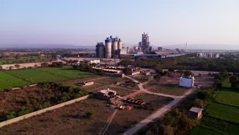 crop fields lands with cement factory and trees at girgita, madhya pradesh, india. sun set time, push in, drone shot, 4k.