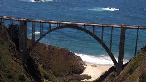 Eine-Filmische-Nahaufnahme-Der-Bixby-Creek-Bridge-An-Der-Küste-Von-Big-Zur-Aus-Der-Luft