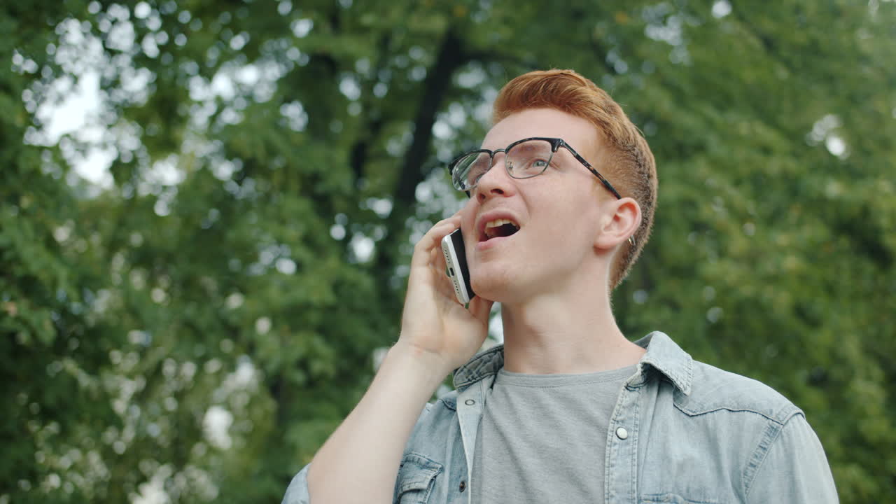 Young Man Talking on Smartphone in a Park