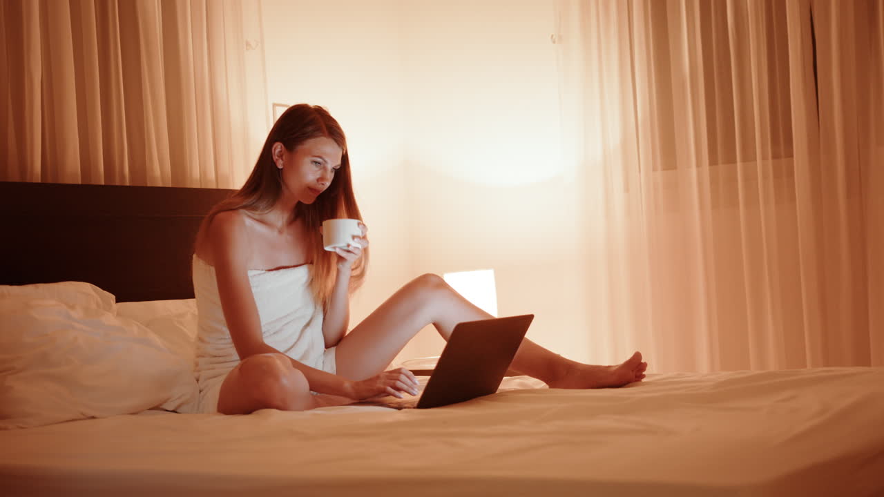 밤에 침대에서 노트북으로 일하는 여자