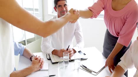 mujeres de negocios estrechando la mano en una reunión.