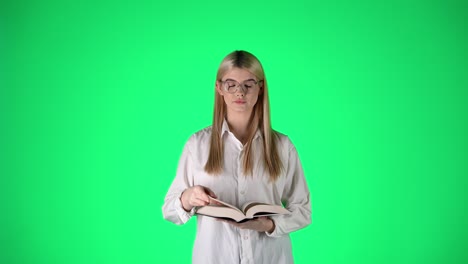 Portrait-Of-Young-Blonde-Woman-Reading-a-Book-Then-Looking-At-Camera,-Studio-Shot-With-Green-Background