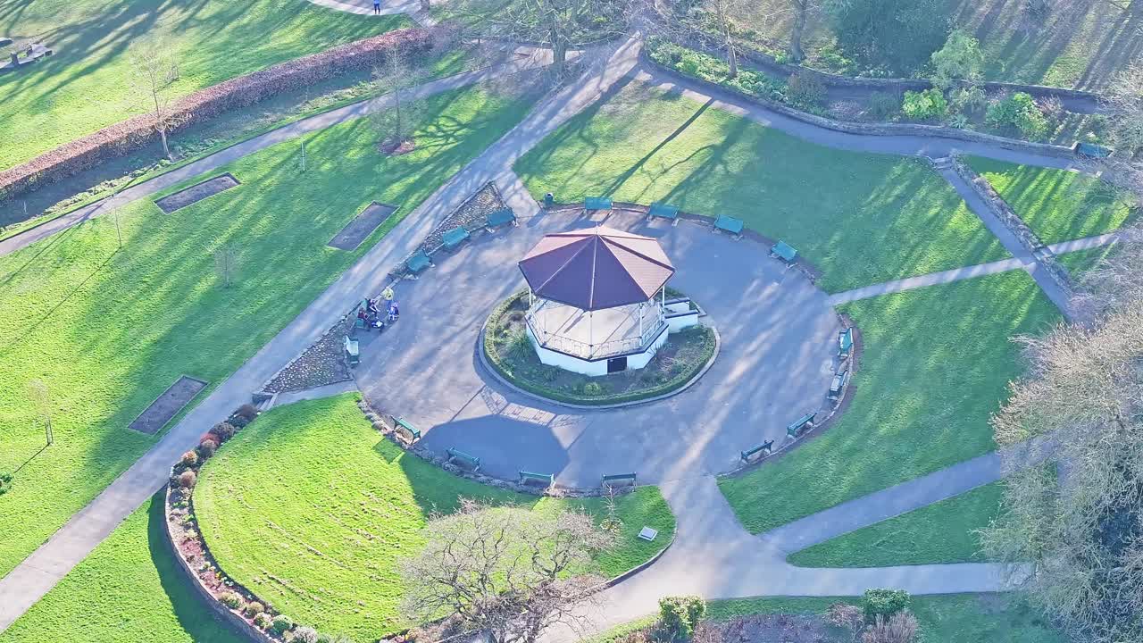 Drone orbits roundhouse and surrounding trees in lush green Elsecar countryside, UK England