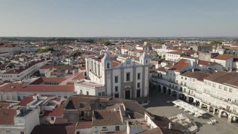 Volando-Hacia-La-Iglesia-De-Santo-Antao-En-La-Plaza-Giraldo,-Centro-De-La-Ciudad-De-Evora,-Alentejo