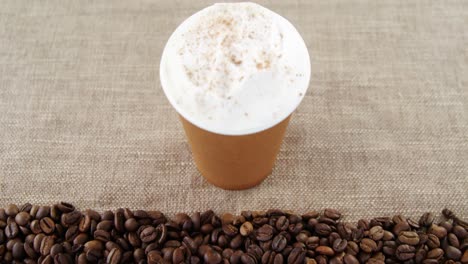 taza desechable con granos de café en una bolsa