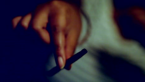 african american female millennial's hand holding a rolled blunt of cannabis-marijuana, closeup pov of just hand