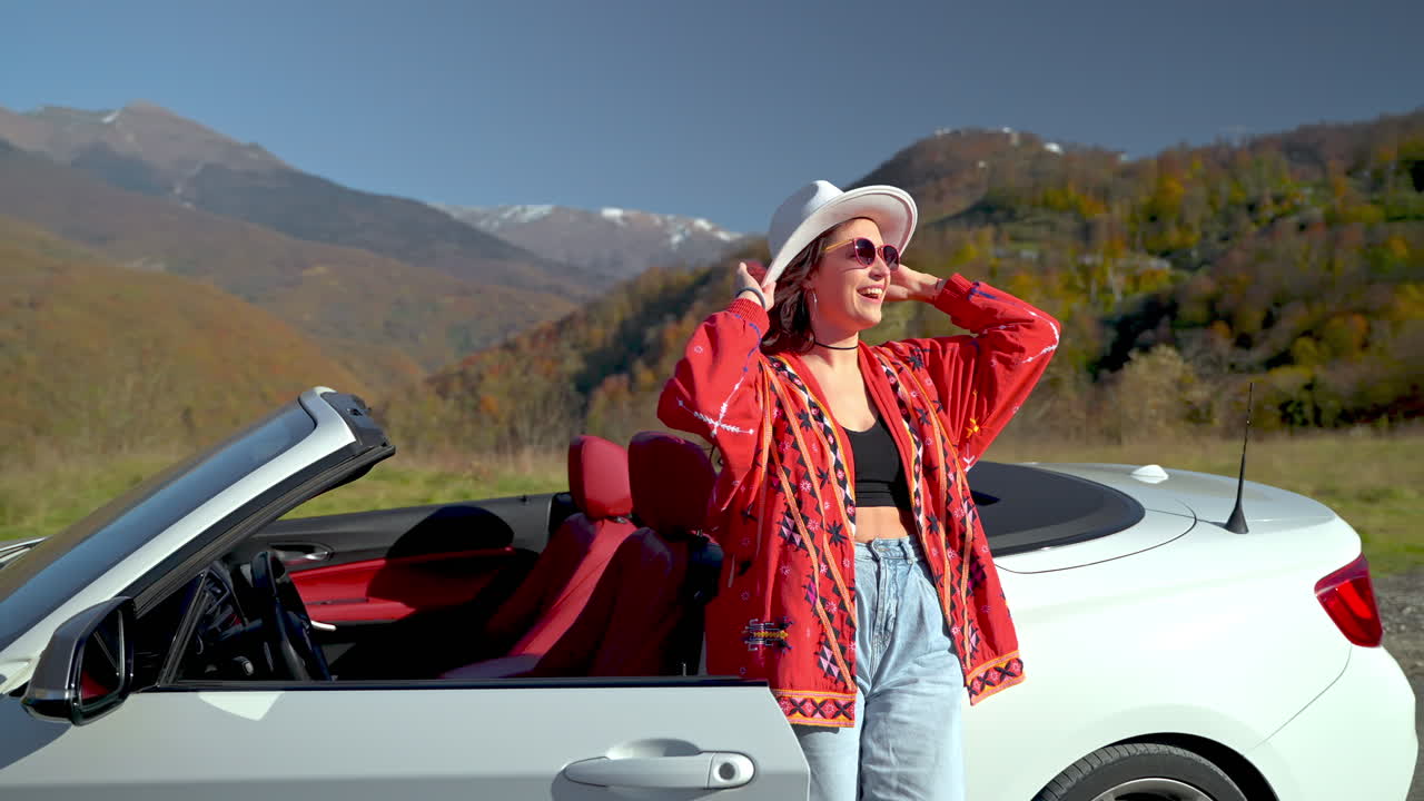 mujer en un coche convertible disfrutando de un pintoresco viaje por carretera de montaña