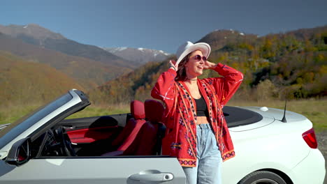 woman in a convertible car enjoying a scenic mountain road trip