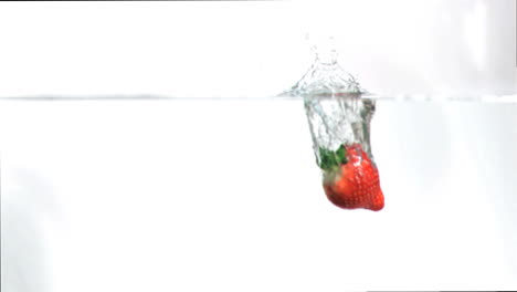 fresa cayendo en el agua en cámara súper lenta