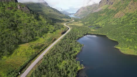 Carretera-Panorámica-A-Través-Del-Fiordo-En-Grindoya,-Islas-Lofoten,-Noruega---Revelación-Aérea-4k-Inclinándose-Hacia-Arriba