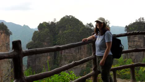happy backpacker at a viewpoint in huangshi village enjoys the lush green mountainous landscape of zhangjiajie, china