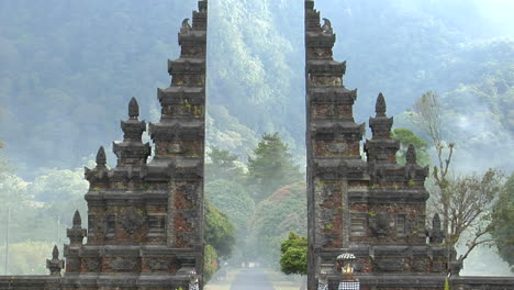 the fog drifts by a traditional balinese temple gate in bali indonesia 2