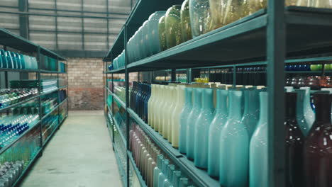 Colorful Glass Vases and Bottles Displayed on Shelves in a Warehouse