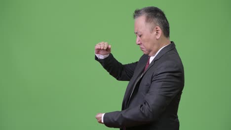 성숙한 일본인 사업가 손가락을 고 무언가를 보여줍니다.
