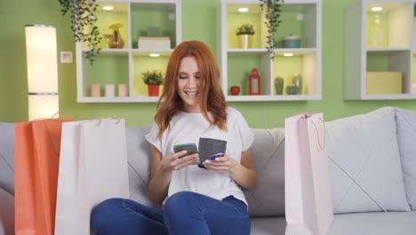 Smiling-cheerful-young-woman-holding-shopping-bags-purchased.