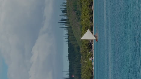 Traditional-Kanak-pirogue-sails-along-Isle-of-Pines-beach-in-Upi-Bay