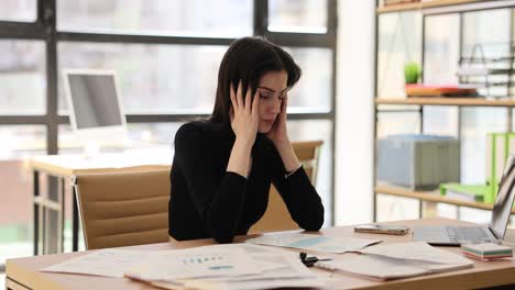 Stressed Woman Suffering from Headache at Office Desk