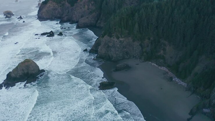 A drone shot of an ocean shore in Northern California. It's a hazy morning