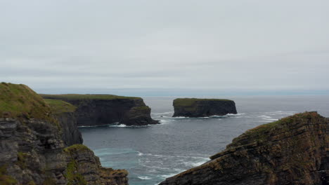 Vorwärts-Fliegen-Entlang-Der-Meeresküste.-Hohe-Klippen,-Felsige-Inseln-Und-Inselchen-In-Wellen.-Luftaufnahmen-Von-Naturlandschaften.-Kilkee-Cliff-Walk,-Irland