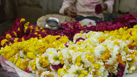 a man stringing flower garlands