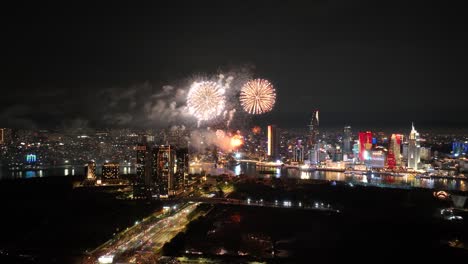 fireworks display over ho chi minh city skyline at night for 50th anniversary reunification day in vietnam. - wide shot