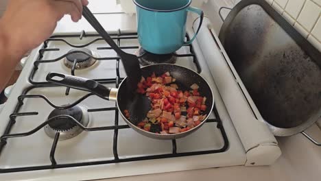 person frying ham and other ingredients in a pan
