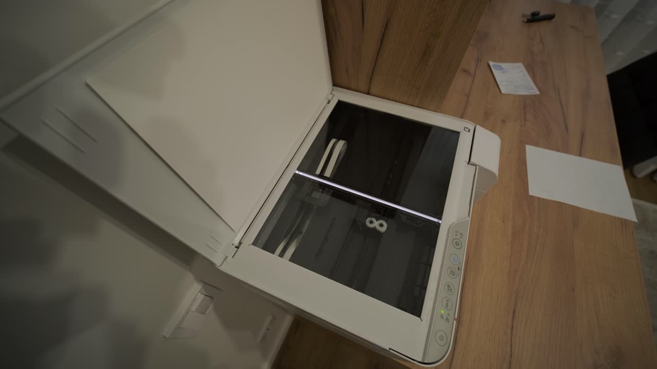 White Multifunction Printer Scanning a Document on a Wooden Desk