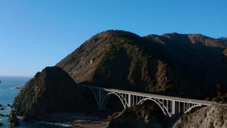 aerial arch towards a short bridge along the california coast