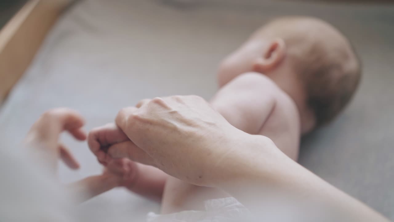 白いおむつに金 ⁇ の小さな男の子が背中に横たわっている