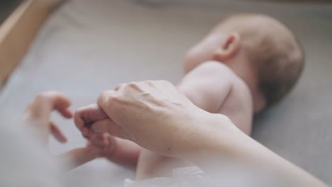 little-boy-with-blond-hair-in-white-diaper-lies-on-back