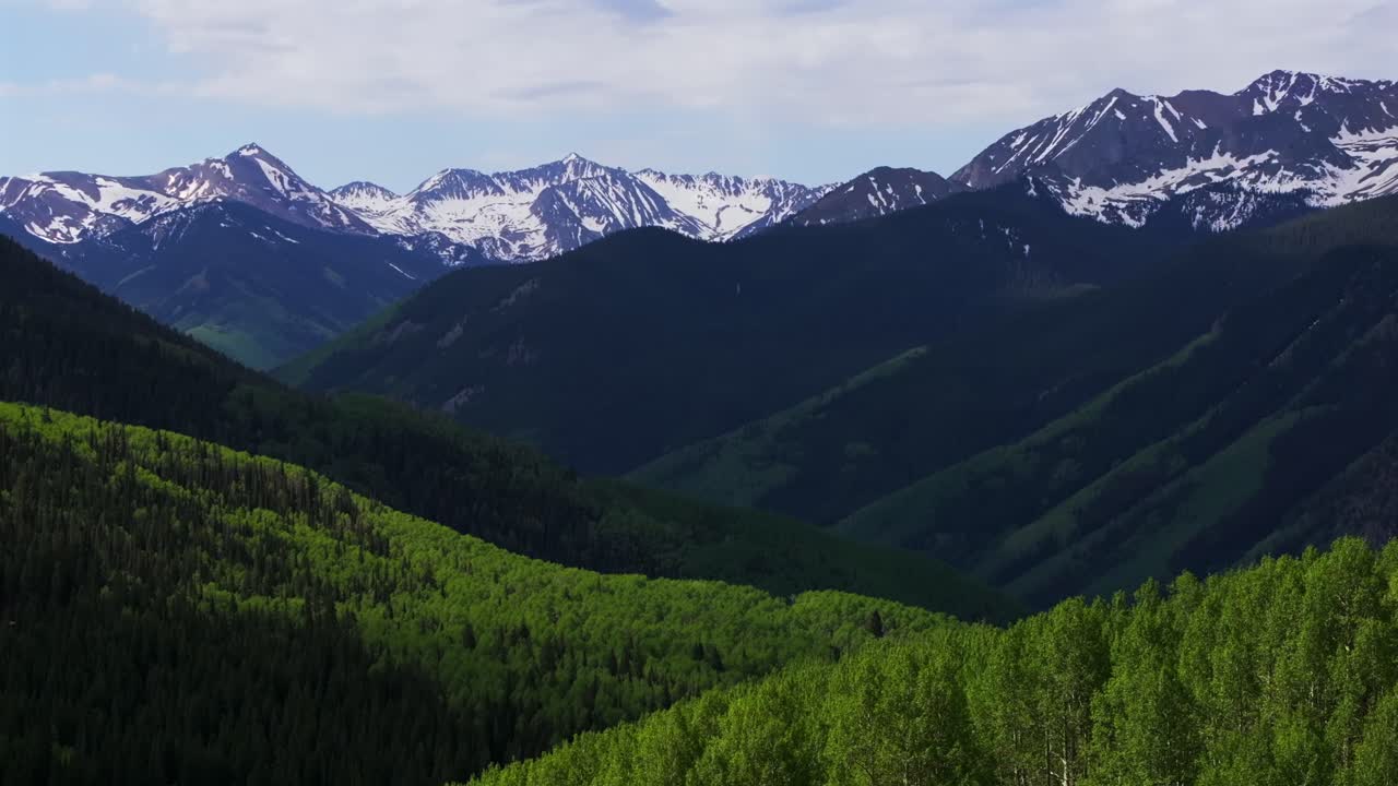 Ashcroft Mountain ghost town spring summertime morning blue sky clouds Aspen Mountain Ajax Little Annie Trailhead aerial drone Colorado scenic Rocky Mountains Elk Range Aspen Trees pan left motion