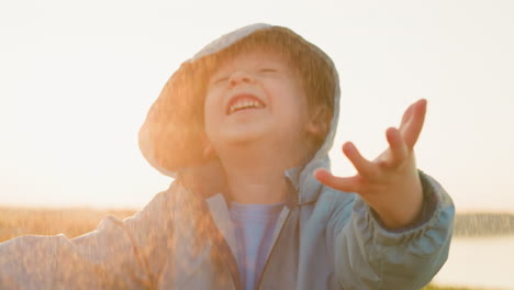 a young boy laughing in the rain