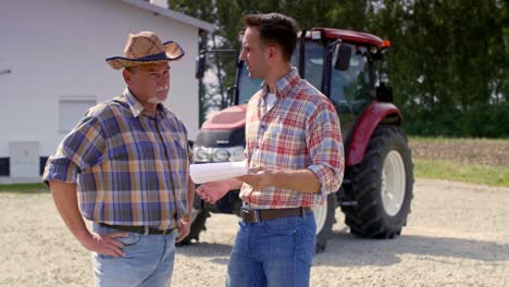 two farmers  analyzing data from the clipboard on the farm