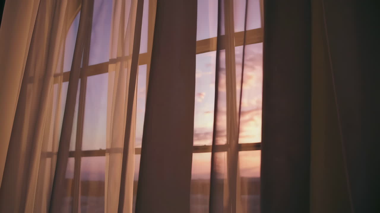 Sunset through a window with curtains