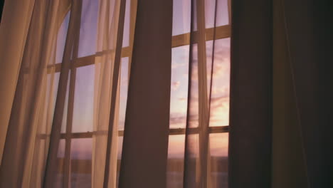 sunset through a window with curtains