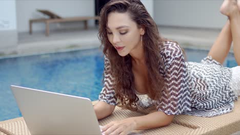 Mujer-Elegante-Con-Laptop-Descansando-En-La-Piscina