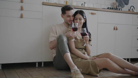 couple enjoying wine in the kitchen