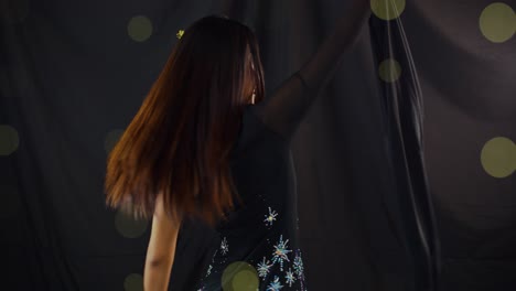 Sexy-young-Asian-woman-dancing-to-the-music-and-smiling-nad-posing-with-black,-bokeh-background