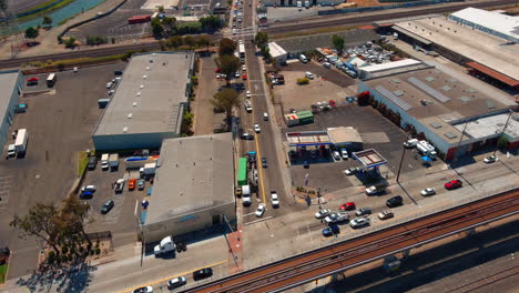 Crane-lifting-container-in-oakland-industrial-area,-sunny-day,-aerial-view