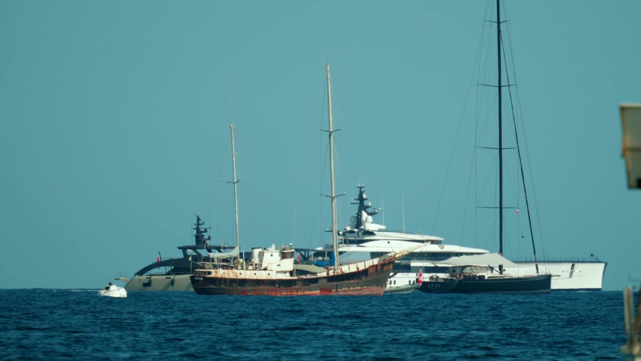 Due grandi yacht di lusso che navigano nell'oceano blu profondo in una giornata di sole, simboleggiando ricchezza, viaggio e tempo libero.