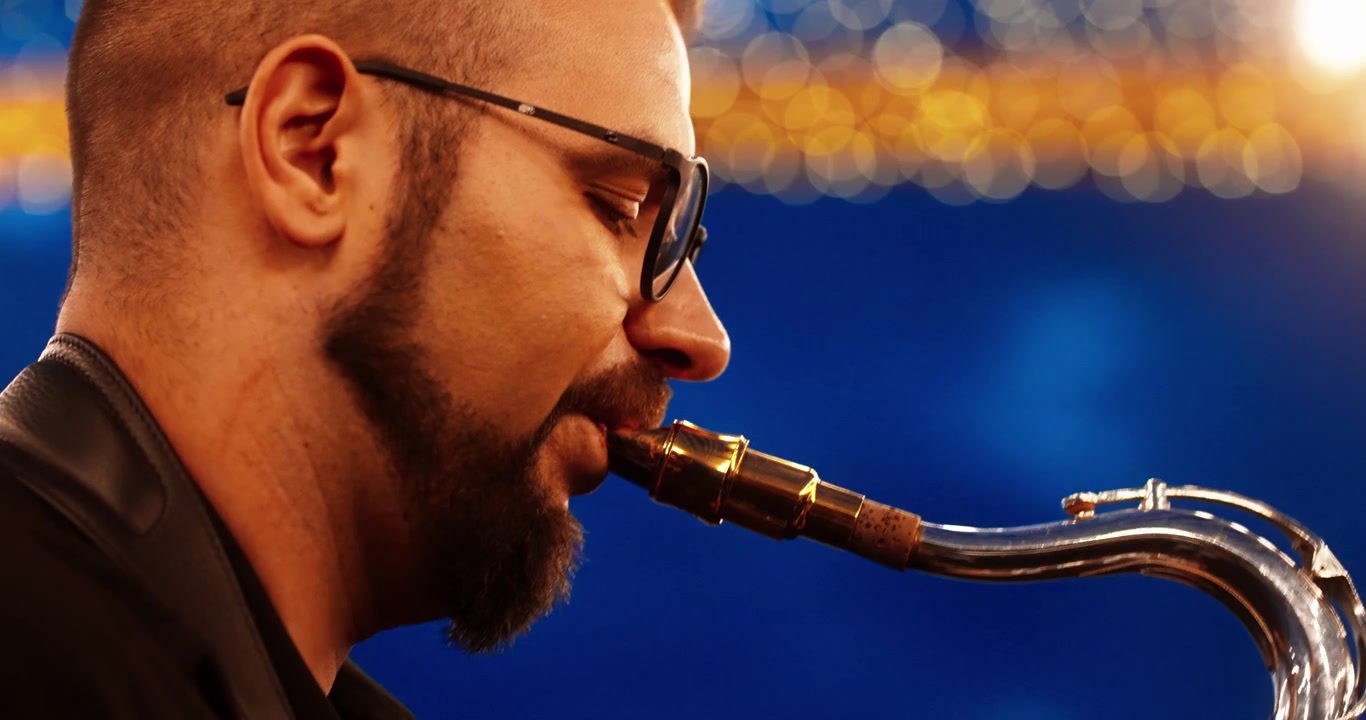 Musicista professionista che suona il sassofono in un locale scarsamente illuminato