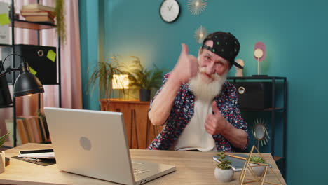 hombre mayor mirando con aprobación a la cámara mostrando los pulgares hacia arriba como una señal de retroalimentación positiva buenas noticias