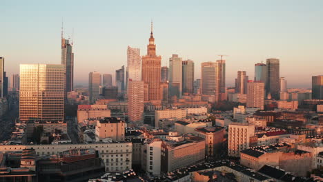 Slide-and-pan-shot-of-high-rise-downtown-buildings-in-sunrise-sunlight.-Morning-panorama-of-city-centre.-Warsaw,-Poland