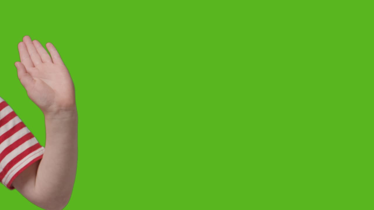 acercamiento de un niño agitando a la cámara contra la pantalla verde