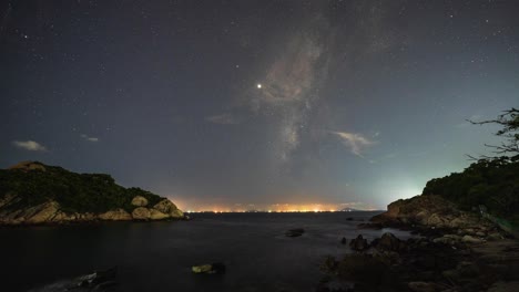 Costa-De-Cheung-Chau-Iluminada-Por-La-Noche-Bajo-La-Enérgica-Vía-Láctea-Avión-Estrella-Fugaz-Cielo-Nocturno-Timelapse