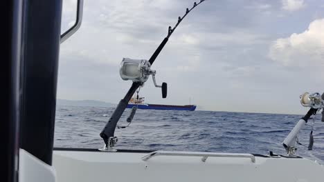 view two fishing rods mounted on rod holders on the fishing boat swimming in the waters of the strait of gibraltar