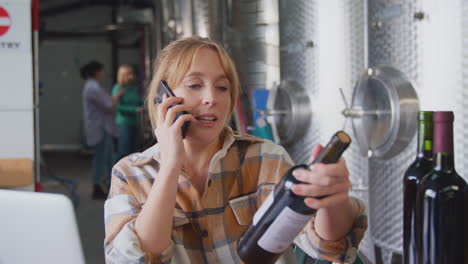 Female-Worker-On-Mobile-Phone-With-Laptop-Checking-Production-Inside-Winery