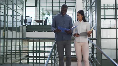 happy diverse female and male business colleagues discussing work at office